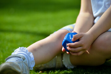 Girl relaxing on grass with a dice. 