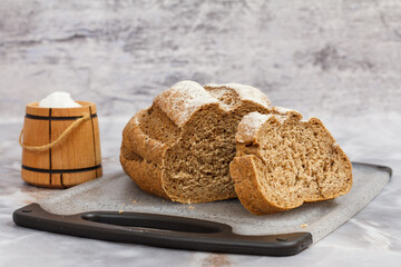 Loaf of bread on cutting board with gray background