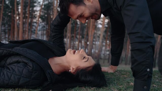 The close-up of the couple in love, the man does push-ups, and when he reaches the bottom, he lovingly kisses his wife. Lifestyle concept of young lovers