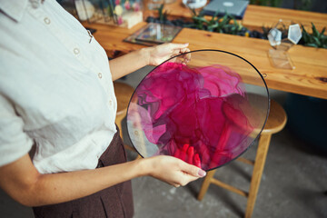 Professional painter examining a beautiful abstract painting in her hands