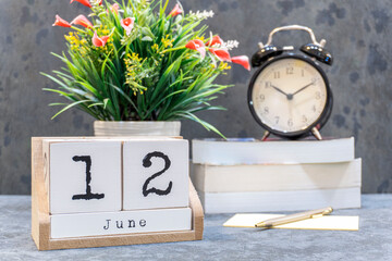 June 12th. June 12 wooden cube calendar with blur objects on background.