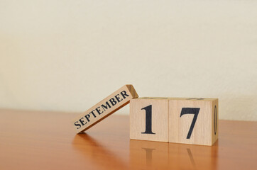 September 17, Date design with calendar cube on wooden table and white background.