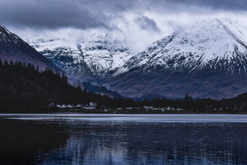 Misty Snow covered Mountains by lake in Glencoe, Scotland