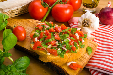 Italian Bruschetta bread on wooden board surrounded by ingredients