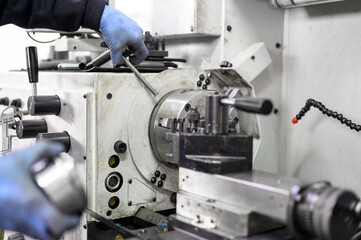 Close up view of worker operating a high precision turning operation on a multi axis lathe, CNC machine tool. High quality photo.