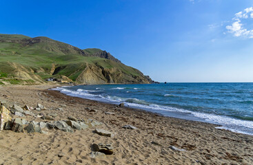 An empty sandy beach at the foot of Cape Meganom. Crimea.
