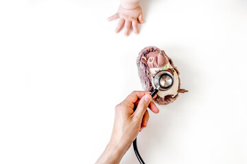 stethoscope, toys and hands on doctor's office desk background top view