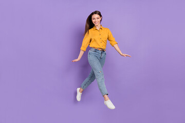 Fototapeta na wymiar Full length body size photo jumping girl smile walking in casual outfit isolated violet color background