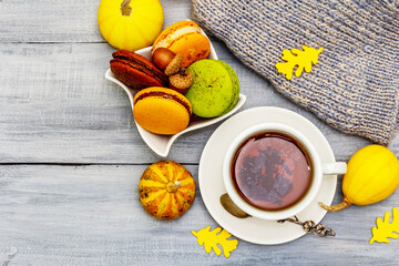 French macarons in autumn colors with cup of hot tea