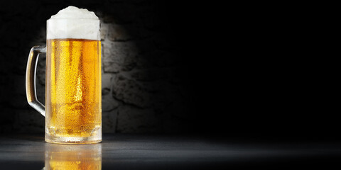 Cold beer on desk and dark background with shadows. 