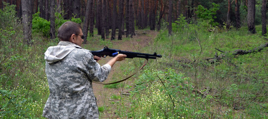 Man with 12-gauge rifle (pump action shotgun). Unformal shooting range near Kiev.