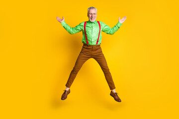 Fototapeta na wymiar Full size photo of senior man happy positive smile active jump feel young isolated over yellow color background