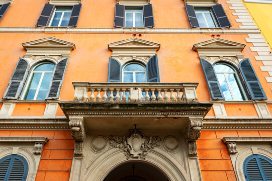 Low angle shot showing details of European classic building with beautiful Italian architectural style window panels located on street of Rome in Italy