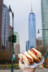 Holding two hot dogs in NYC on the street
