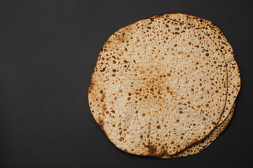 Tasty matzos on black background, top view with space for text. Passover (Pesach) celebration