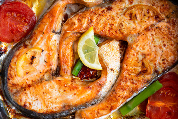 Salmon stake cooked with lemon, tomatoes and asparagus