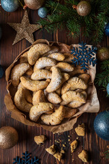 Homemade Christmas nuts cookies vanilla crescent with sugar powder in Christmas decorations. New Year and Christmas celebration concept. Copy space. Soft focus. Flying sugar powder