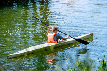 Youth floating in a canoe on the river
