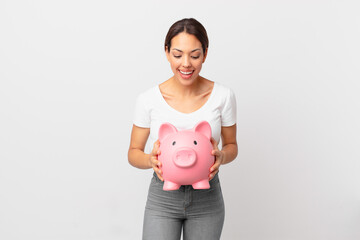 young hispanic woman with a piggy bank