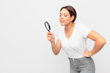 young hispanic woman holding a magnifying glass