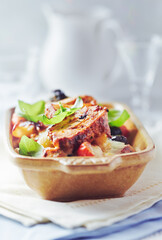 Pork tenderloin baked with Penne pasta, cherry tomatoes, black olives and cheese. Bright background. Close up