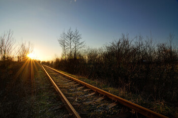 Obraz na płótnie Canvas Railroad track in sunset sky with sun.