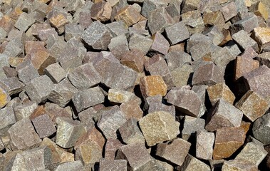 Large heap of porphyry cubes ready to be used for sidewalk or exterior pavement. Construction materials. Background and texture. - obrazy, fototapety, plakaty
