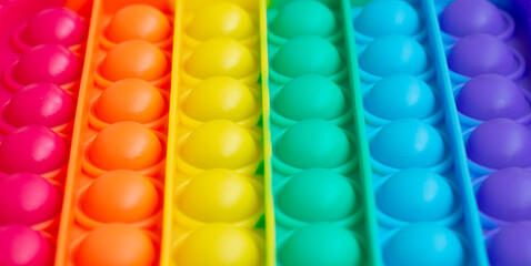 Close up.a new sensory toy - pop it, antistress concept.Rainbow color. Convex bubbles