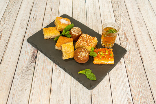 Various types of sweet arabic baklava and a glass of Moorish tea