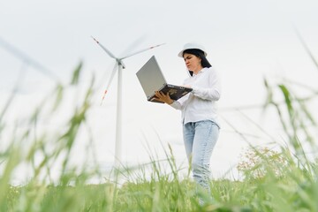 Environmental engineer with a laptop at wind farm