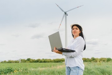 Environmental engineer with a laptop at wind farm