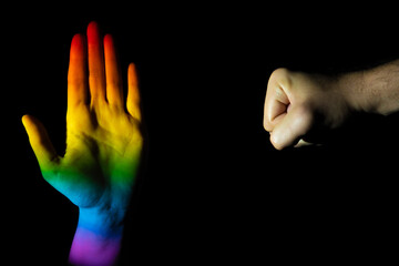 Hands making a stop and punch gesture on a black background