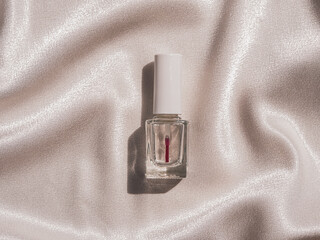 Nail polish bottle mockup with harsh shadow on white silk background french manicure cosmetics...