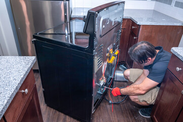 Appliance technician troubleshooting an electric range