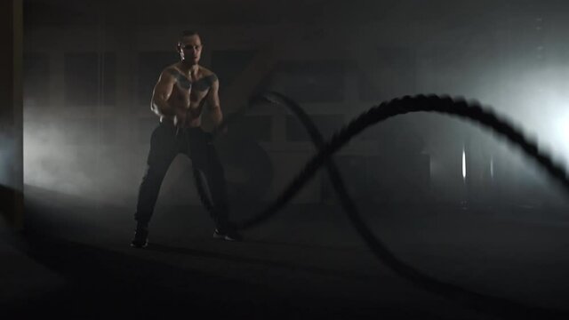 Bodybuilder working out with gunex ropes with incredible speed,gym.