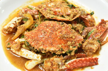 stir fried swimmer crab in yellow curry and egg on plate