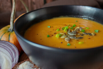 Close up on pumpkin soup in a black bowl