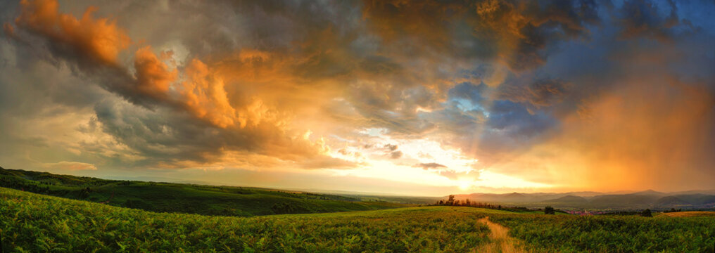 Majestic sunset with storm clouds. Panorama in countryside