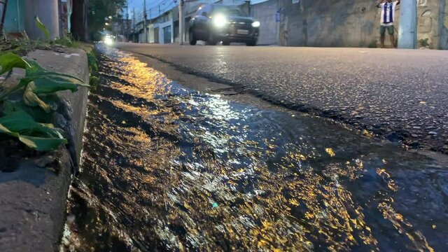 Water sewage flowing in street after rain