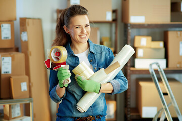 Portrait of happy young woman in jeans in warehouse