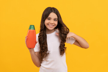 happy girl hold shampoo bottle. child with hair conditioner. daily habits and personal care.