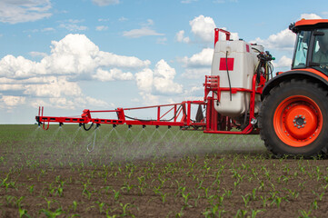 Tractor spraying pesticides at corn fields