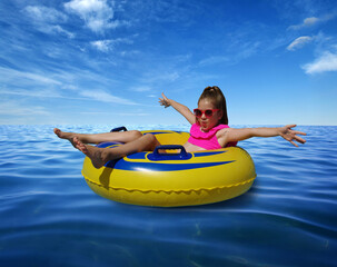 Obraz premium Little girl on inflatable ring in blue sea water