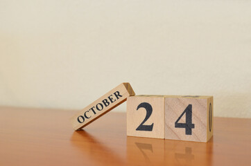 October 24, Date design with calendar cube on wooden table and white background.