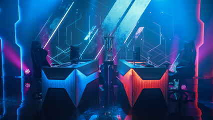 Two Person Empty Computer Gaming eSports Championship Arena with Winner Trophy Standing on a Stage. Stylish Online Live Streaming Tournament with Big Screens Showing Graphics and Neon Stage © Gorodenkoff
