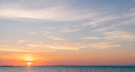 Sunset sky over sea in the evening with colorful orange sunlight horizon sky, dusk sky background
