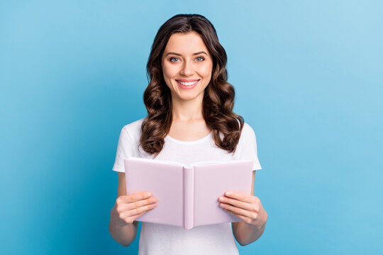 Photo of young attractive girl happy positive smile read book notebook story novel isolated over blue color background