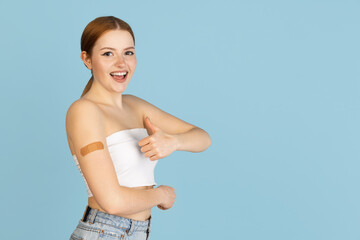 Caucasian woman's portrait isolated over blue studio background with copyspace for ad. Concept of...