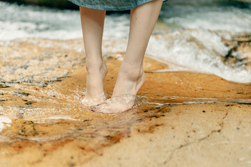 川に入る女性の足
