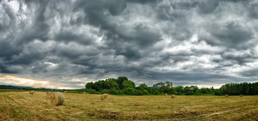 Hay bales in a dramatic sky